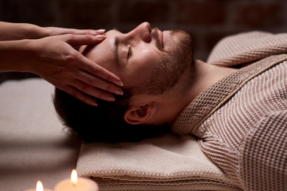 Smiling man undergoing facial beauty treatment